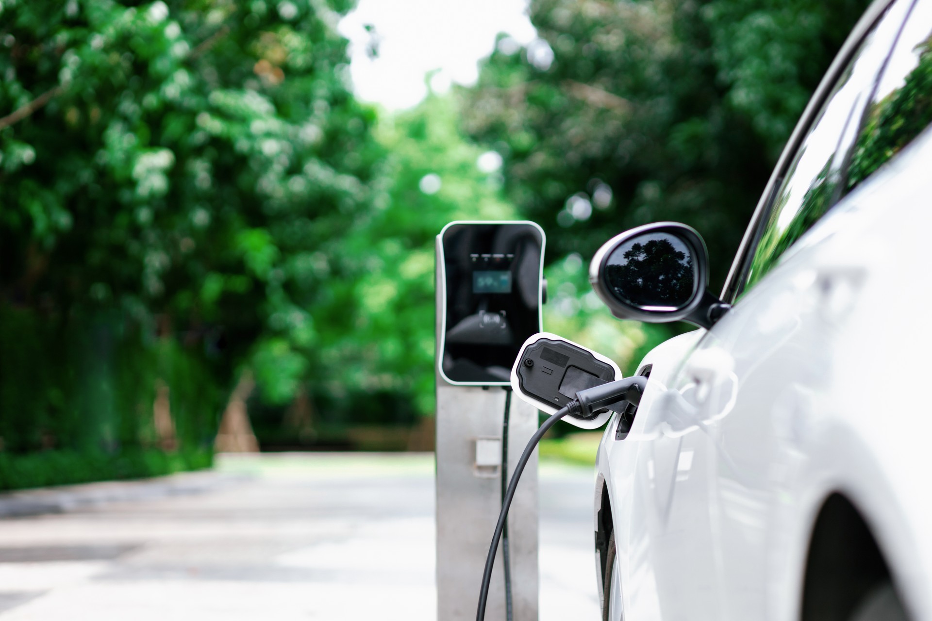 Focus closeup EV car and charger with blur background for progressive concept