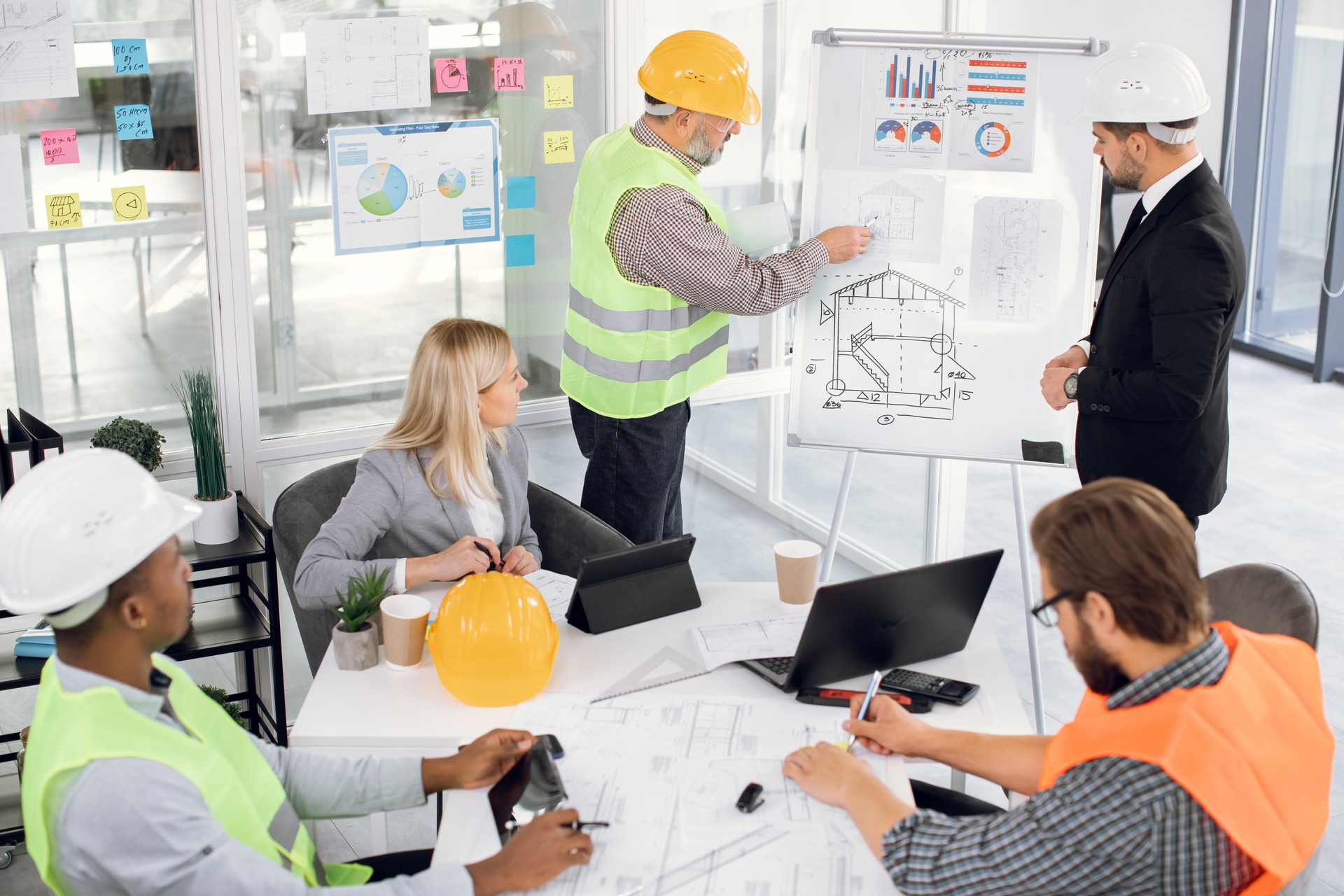 Male and female colleagues analysing blueprints at office