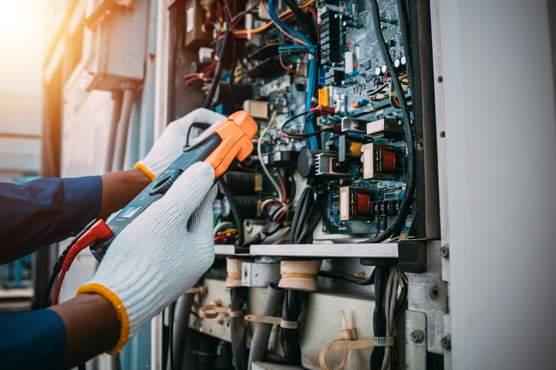 Technician is checking air conditioner refrigerant system maintenance and check switch board control